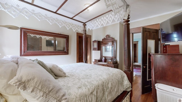 bedroom with crown molding and dark hardwood / wood-style floors