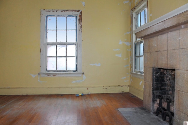 unfurnished living room with a fireplace, plenty of natural light, and hardwood / wood-style floors