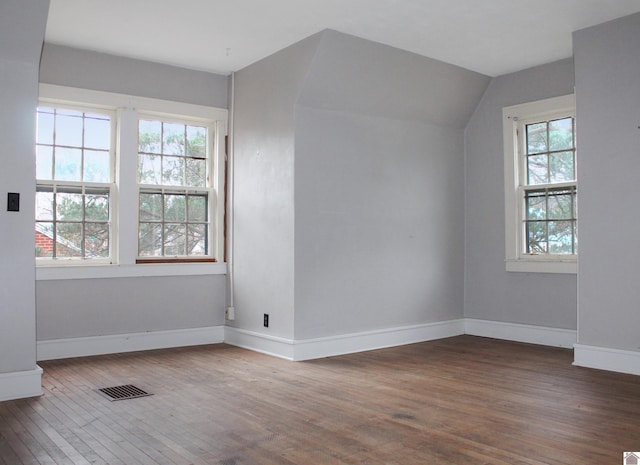 bonus room with plenty of natural light, dark hardwood / wood-style flooring, and lofted ceiling