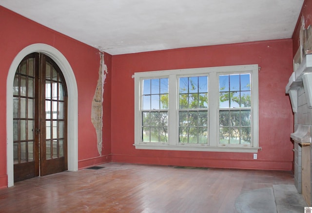 spare room with hardwood / wood-style floors, a healthy amount of sunlight, and french doors