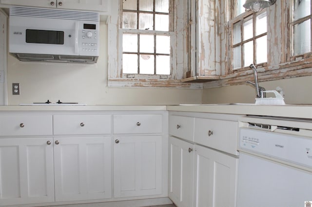 kitchen with white cabinetry, sink, and white appliances