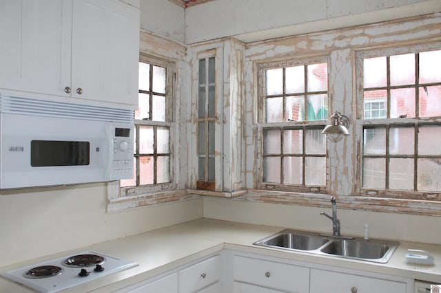 kitchen featuring sink, white appliances, white cabinets, and a healthy amount of sunlight