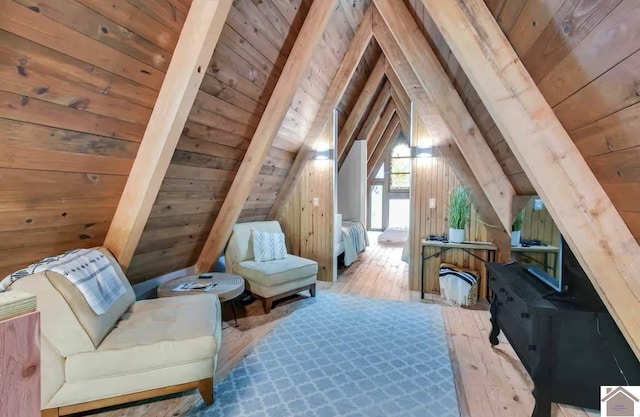 living area with wood walls, wooden ceiling, lofted ceiling with beams, and light hardwood / wood-style floors