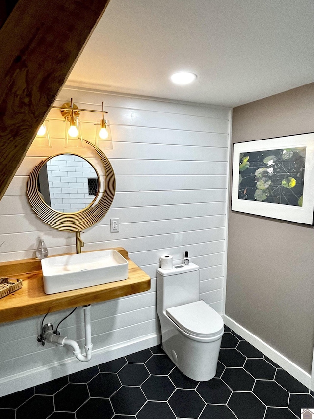 bathroom featuring toilet, tile patterned flooring, and sink