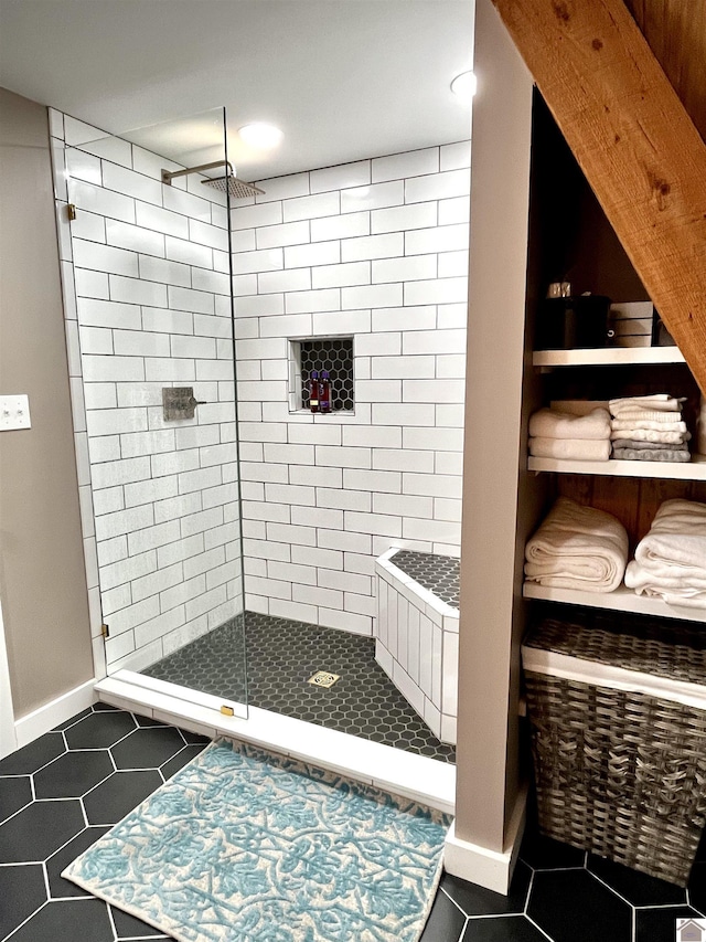 bathroom featuring a tile shower and tile patterned flooring