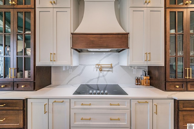 bar with white cabinets, backsplash, black electric stovetop, and custom exhaust hood