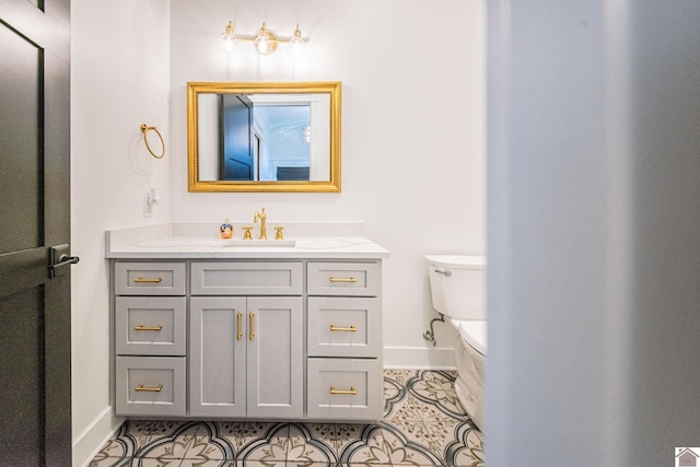 bathroom with toilet, vanity, and tile patterned floors