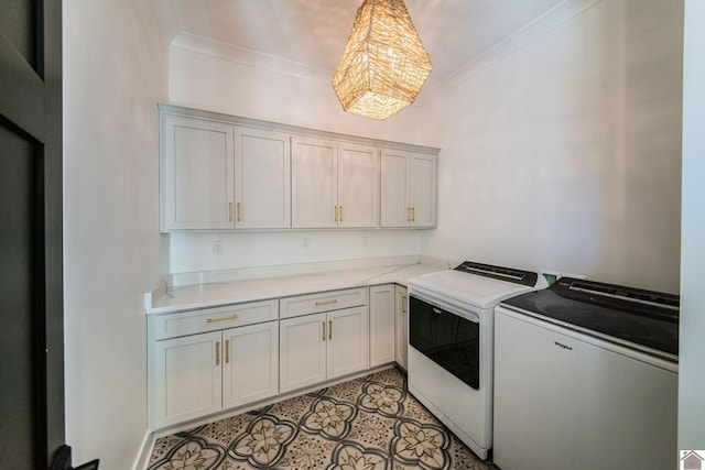 laundry room featuring cabinets, ornamental molding, and separate washer and dryer