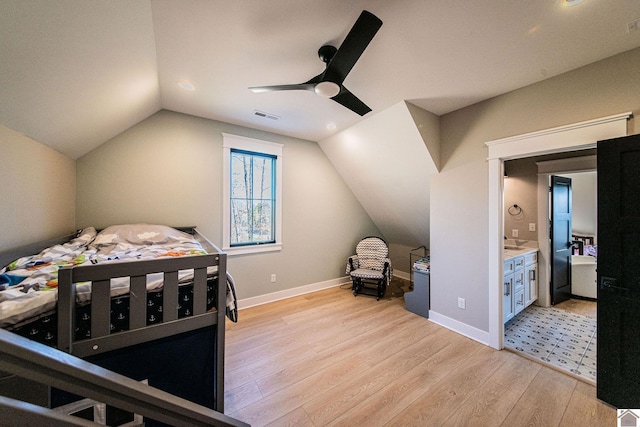 bedroom with ceiling fan, light wood-type flooring, ensuite bathroom, and lofted ceiling