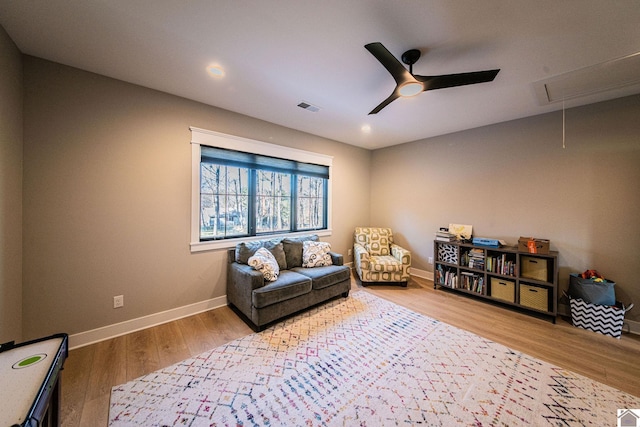 sitting room with ceiling fan and hardwood / wood-style floors