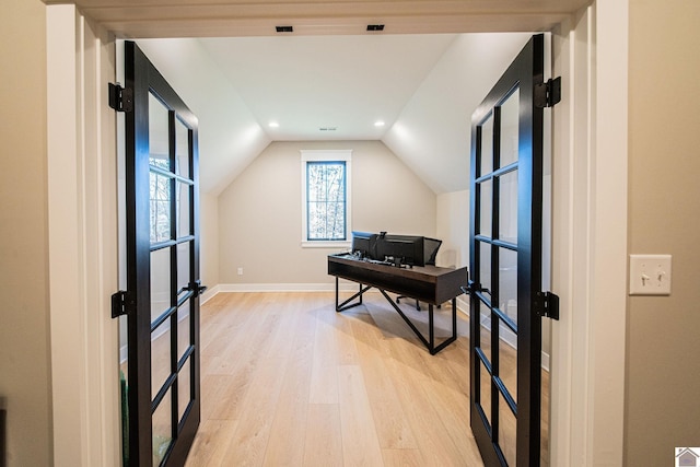 office featuring lofted ceiling, light wood-type flooring, and french doors