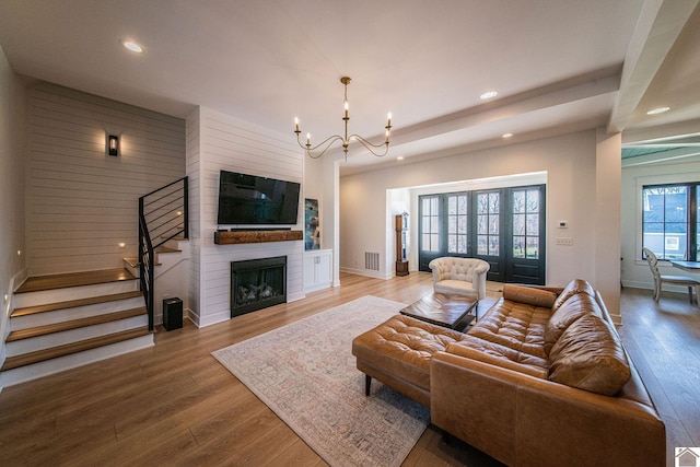 living room featuring a chandelier, a fireplace, and hardwood / wood-style flooring