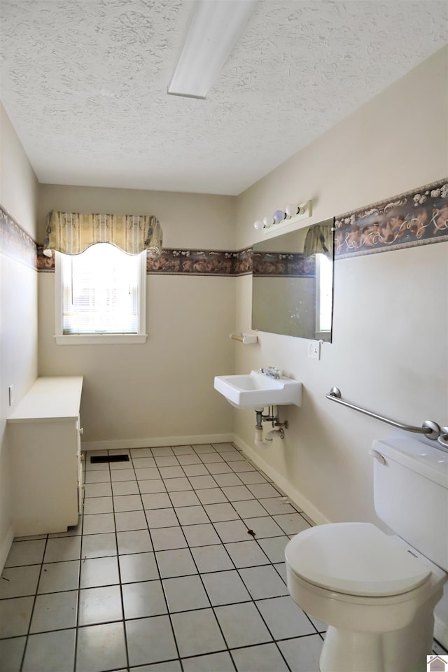 bathroom with toilet, tile patterned flooring, and a textured ceiling