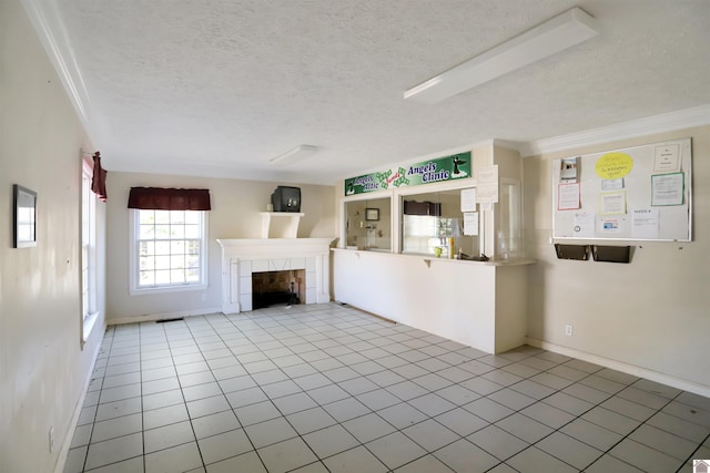 unfurnished living room with a textured ceiling, light tile patterned floors, and a tile fireplace