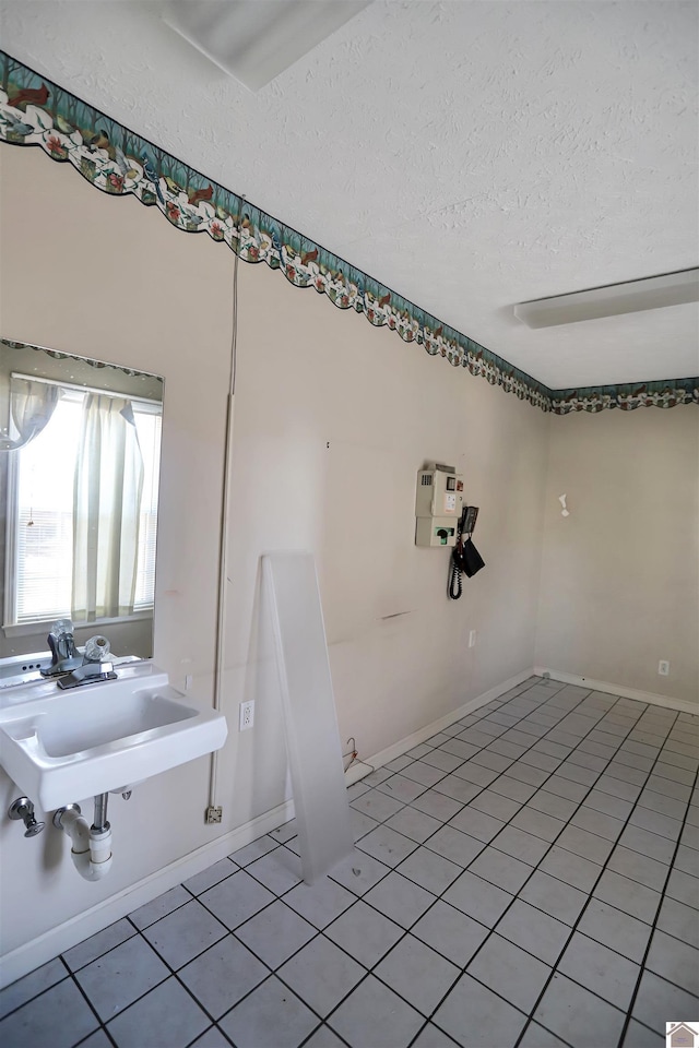 bathroom with a textured ceiling and tile patterned floors