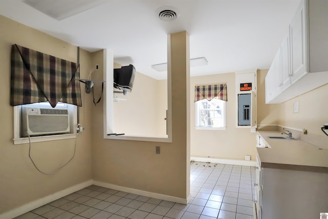 interior space with sink, cooling unit, white cabinets, and light tile patterned flooring