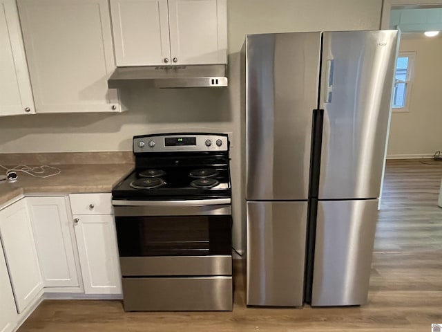 kitchen with light wood-type flooring, appliances with stainless steel finishes, and white cabinetry