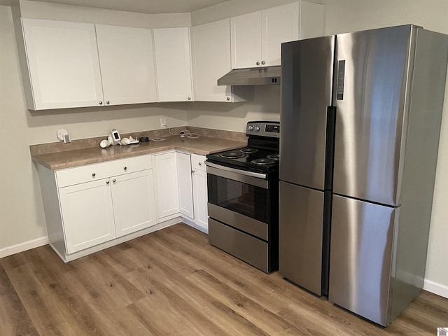 kitchen with white cabinets, wood-type flooring, and appliances with stainless steel finishes