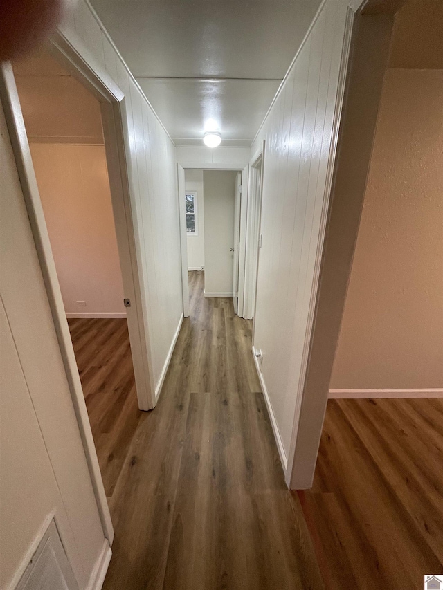 hall featuring hardwood / wood-style flooring and wood walls