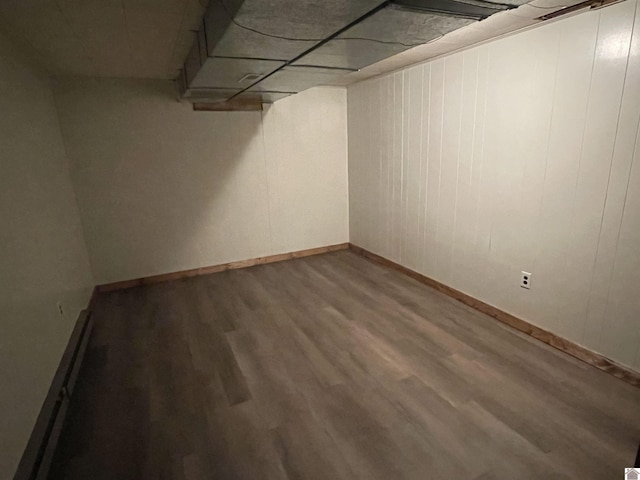 basement featuring a baseboard radiator and wood-type flooring