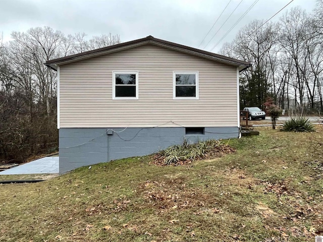 view of side of home with a lawn