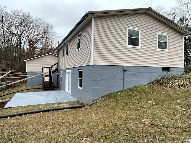 view of home's exterior featuring a lawn and a patio