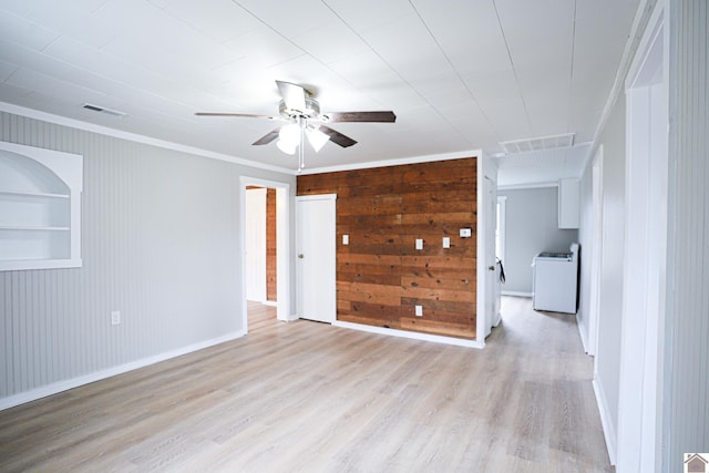 unfurnished room with washer / dryer, ceiling fan, light wood-type flooring, ornamental molding, and built in shelves