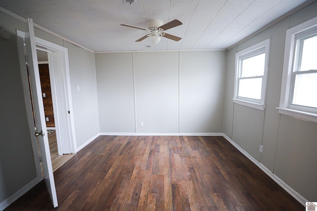 unfurnished room featuring dark wood-type flooring, crown molding, and ceiling fan