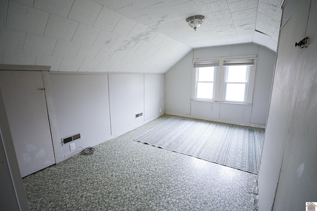 additional living space featuring lofted ceiling