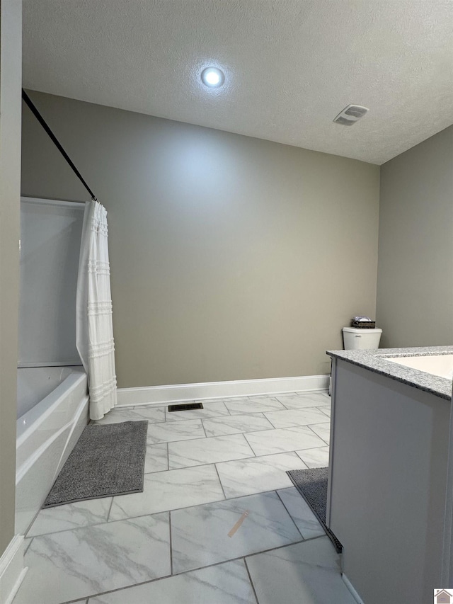 bathroom with a textured ceiling, vanity, and shower / bath combination with curtain