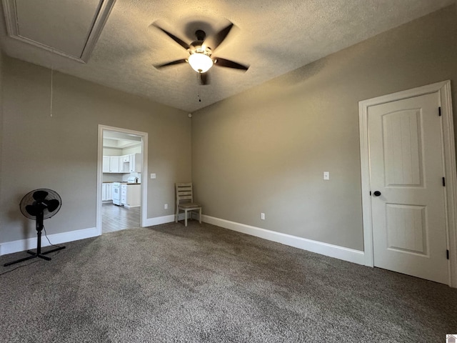 carpeted empty room with ceiling fan and a textured ceiling