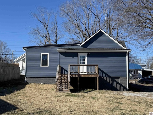 rear view of property featuring a wooden deck and a yard