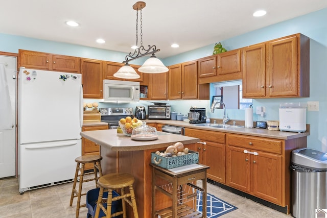 kitchen featuring stainless steel appliances, a center island, decorative light fixtures, a breakfast bar, and sink