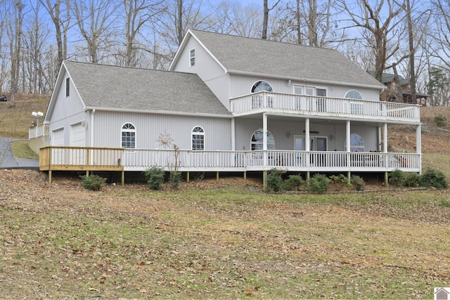 view of front of home featuring a front yard, a garage, and a balcony