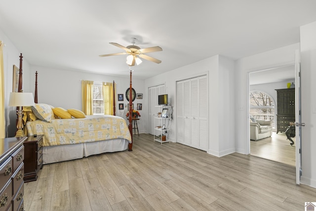 bedroom featuring ceiling fan, two closets, and light hardwood / wood-style flooring