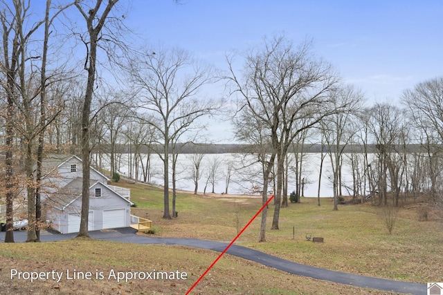 view of yard with a garage and a water view