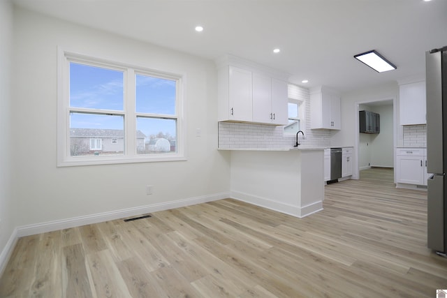 kitchen with sink, white cabinetry, backsplash, and dishwasher