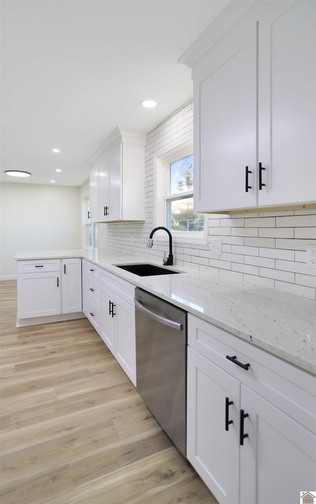 kitchen with white cabinetry, stainless steel dishwasher, and sink