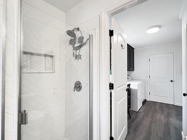 bathroom featuring wood-type flooring, an enclosed shower, and independent washer and dryer