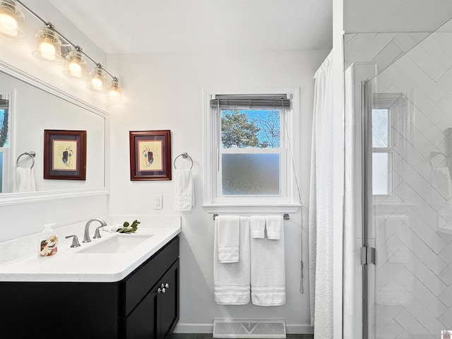 bathroom with a shower with shower door and vanity