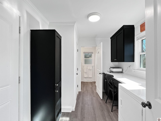 laundry area with cabinets, crown molding, and hardwood / wood-style flooring