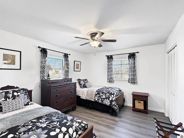 bedroom with ceiling fan, multiple windows, and a closet