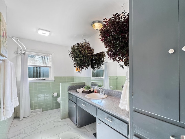 bathroom with toilet, tile walls, and vanity