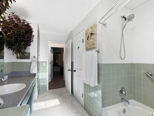 bathroom with tile walls,  shower combination, and vanity