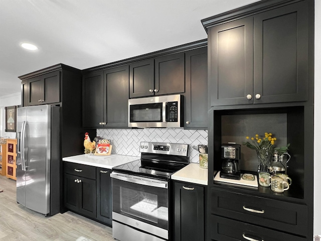 kitchen featuring light wood-type flooring, stainless steel appliances, crown molding, and tasteful backsplash