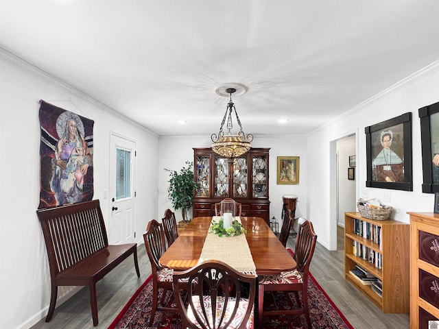 dining room with an inviting chandelier, ornamental molding, and hardwood / wood-style floors