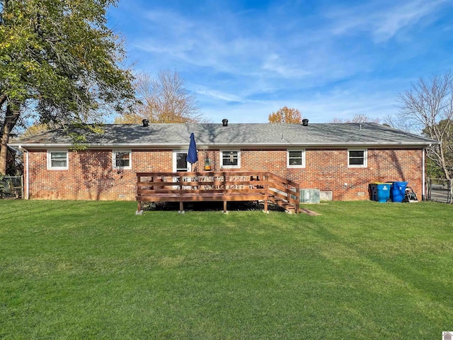 rear view of house featuring a wooden deck and a yard