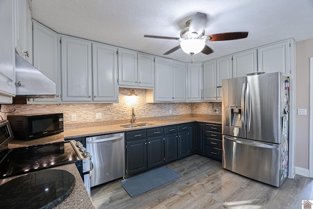 kitchen featuring appliances with stainless steel finishes, white cabinetry, light hardwood / wood-style floors, sink, and blue cabinetry