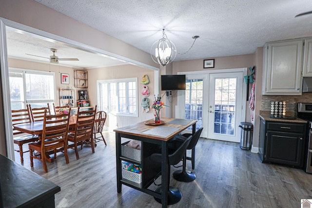 dining area featuring wood-type flooring, a textured ceiling, and french doors