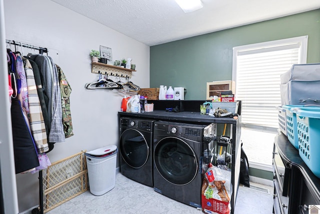 laundry room featuring a textured ceiling and washer and clothes dryer